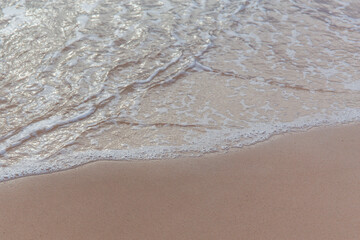 Selective focused on sea foam water at sand beach.
