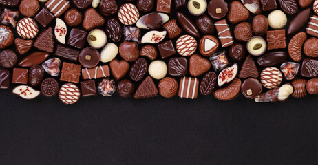 chocolate candy on black table with copy space, sweet food background.