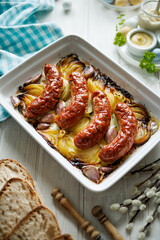Baked white sausage with the addition of onion, garlic and herbs in a baking dish, top view. Easter food - 491069961