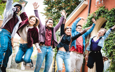 University college students jumping and cheering by end of school at campus yard - Trendy life...