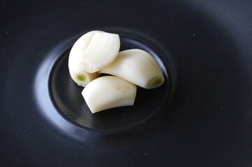 Fototapeta na wymiar garlic cloves on a black plate