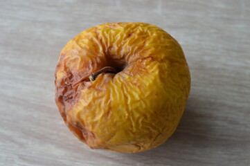 a yellow rotten apple on a wooden table