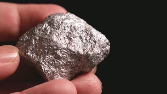 Miners hold in their hands platinum or silver or rare earth minerals found in the mine for inspection and consideration