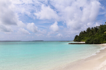 Fototapeta premium Maldives, a beach with the white sand near the turquoise ocean. Summer vacation on a paradise tropical island.