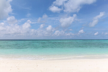 Fototapeta na wymiar Maldives, a beach with the white sand near the turquoise ocean. Clear skyline.
