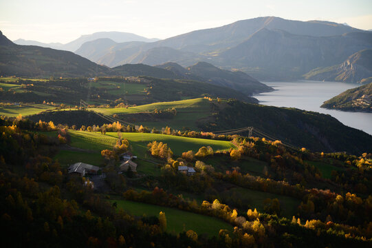 smooth hilly landscape with farms and green spring meadows in morning light