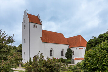 white scandinavian church with a tall tower against the blue sky - Powered by Adobe
