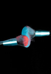 Make up brushes colliding and exploding with powder