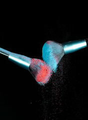 Make up brushes colliding and exploding with powder