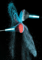 Make up brushes colliding together and exploding with powder