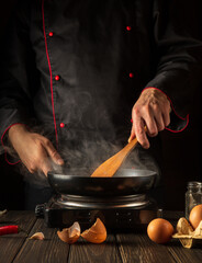 Cooking egg omelette for breakfast rookie chef in the kitchen. Delicious recipe idea for hotel or restaurant