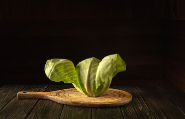 Head of cabbage on a cutting board in a restaurant kitchen. Vegetarian diet or cuisine. Free space for hotel menu