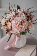 Bouquet with roses, hydrangea. Stabilized flowers in a white ceramic vase at home on the dressing table. Interior decor.