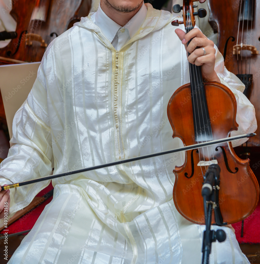 Wall mural A Moroccan player wearing a djellaba plays a violin called Andalusian art in Morocco and Algeria