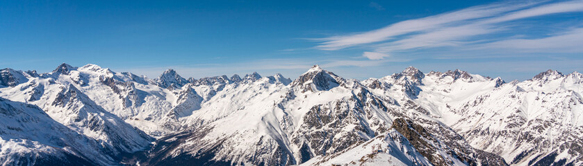 Obraz premium Panoramic view of winter snowy mountains in Caucasus region in Russia with blue sky