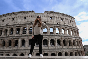 Tourist girl posing in front of Colosseum in Rome, Italy