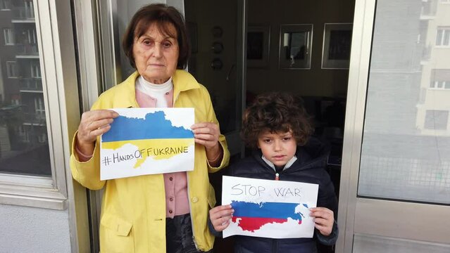 Grandmother and child grandson protest against the war between Russia and Ukraine with no war signs