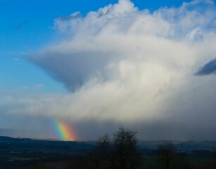 Nuage de pluie formant un arc en ciel.