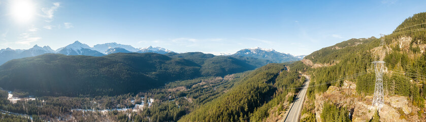 Aerial Panoramic View of Sea to Sky Highway in a valley by mountains. Sunny Winter Day. Located...