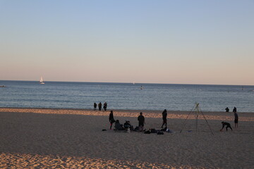 people playing and relaxing on the beach, sunset on the beach 