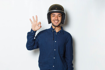 handsome man with a motorcycle helmet showing a thumbs up ok gesture on white background

