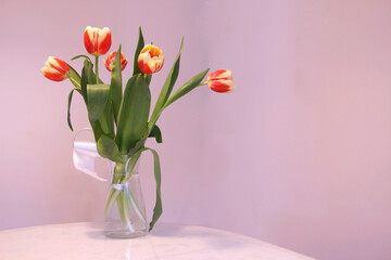 Spring flowers - tulips, on the table in a glass vase