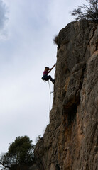 MUJER ESCALANDO UNA PARED ROCOSA