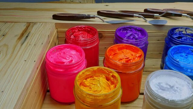 .colorful of ink in the glass bucket placed in wooden crates..plastisol ink for print tee shirt in the transparent glass bucket..colorful of ink background. stock footage colorful paint concept.