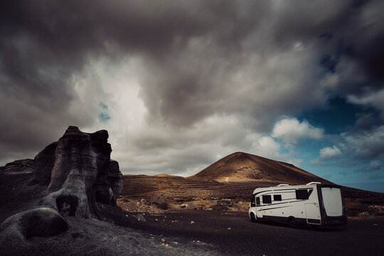 Modern camper van camp site in a scenic landscape destination with mountains and cloudy sky in background. Van life alternativ ehome concept lifestyle for traveler and adventurer