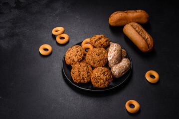 Tasty fresh oat cookies on a dark concrete background