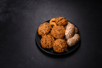 Tasty fresh oat cookies on a dark concrete background