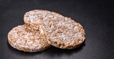 Three round crunchy buckwheat crispbread on a dark concrete background