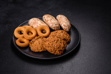 Tasty fresh oat cookies on a dark concrete background