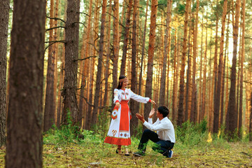 a girl in national Chuvash clothes and her boyfriend in a pine forest