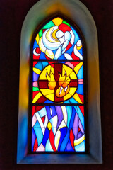 Decorative stained glass with motives from Christian religion used on windows in catholic church in...
