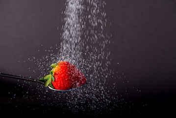 Sugar poured on a strawberry