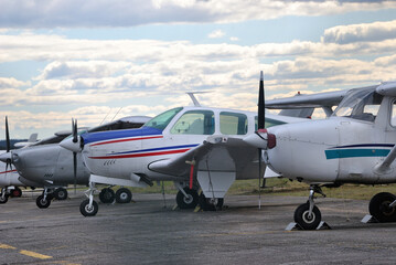 Avionetas paradas num aeródromo com nuvens no céu em forma de linha