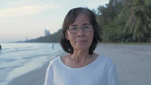 Travel concept of 4k Resolution. Asian elderly woman smiling confidently on the beach.