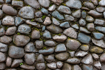Old stone wall covered with clumps of green moss and lichen