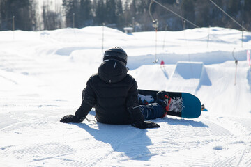 Fototapeta na wymiar Snowboarder and Snowboard. A snowboarder goes snowboarding downhill in winter.