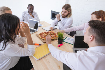Diverse team workers eating pizza