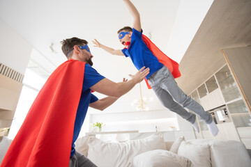 Father holding son in superhero costume