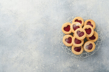 Traditional Linzer cookie with strawberry jam and powder sugar on light grey beautiful background. Top view. Traditional homemade Austrian sweet dessert food on Valentines Day. Holiday snack concept.