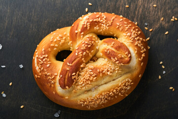 Bavarian pretzels and glass of lager beer. Oktoberfest food menu, traditional salted pretzels over old dark wooden background. Top view with space for text. Oktoberfest theme