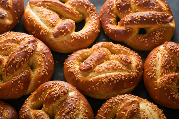 Bavarian pretzels and glass of lager beer. Oktoberfest food menu, traditional salted pretzels over old dark wooden background. Top view with space for text. Oktoberfest theme