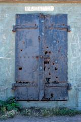 old black rusty metal door at a concrete wall
