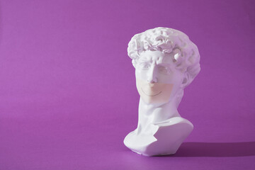 copy of head of antique statue of David with sealed mouth purple background, trendy colors, smile...
