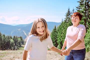Fototapeta na wymiar family grandmother and mother in mountains happy to travel. Leisure family time, summer concept