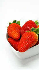 Fresas en recipiente forma de corazón sobre fondo blanco