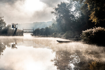 Foggy Landscape With Boats On River Bank And Bridge In River Danube National Park In Austria